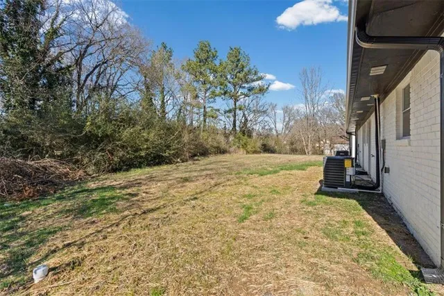 a view of a yard with plants and trees
