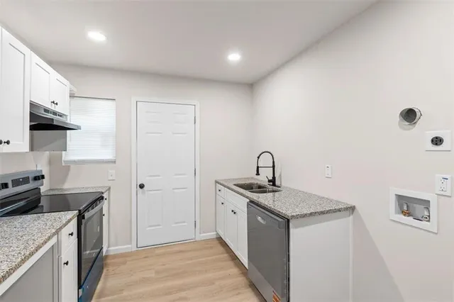 a kitchen that has a sink a stove and a microwave