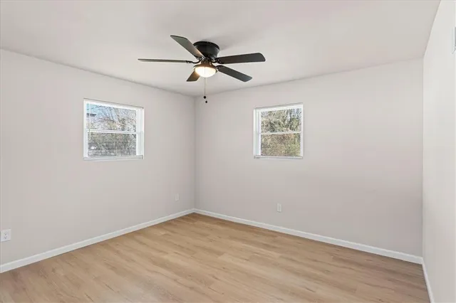 an empty room with wooden floor and window