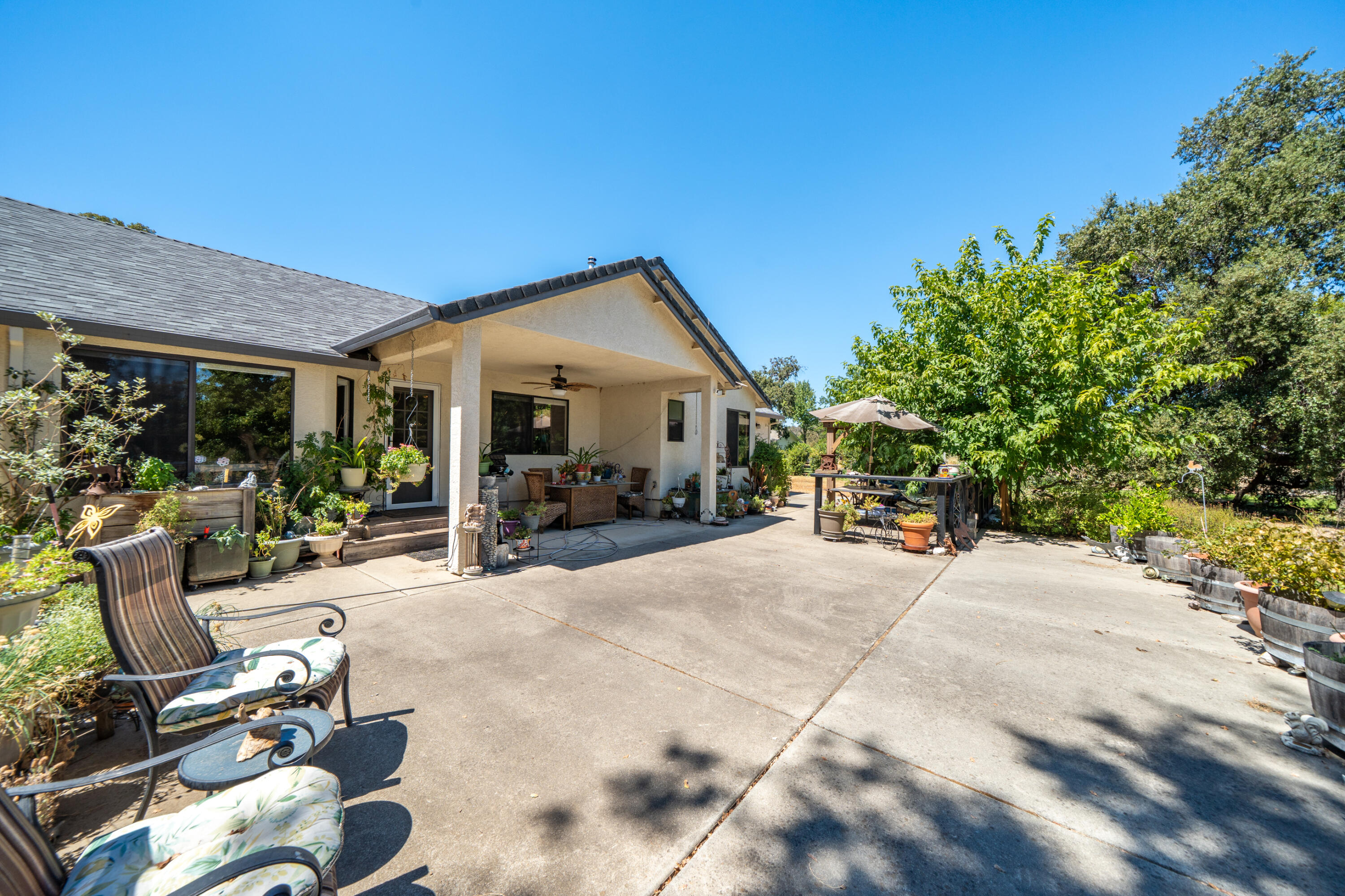 8533 Maynard Road Palo Cedro, CA 96073 - Photo 34 of 100 a view of a patio with table and chairs potted plants and floor to ceiling window