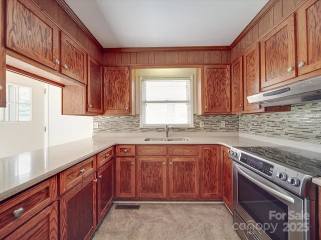 a kitchen with stainless steel appliances granite countertop wooden cabinets a sink and a window