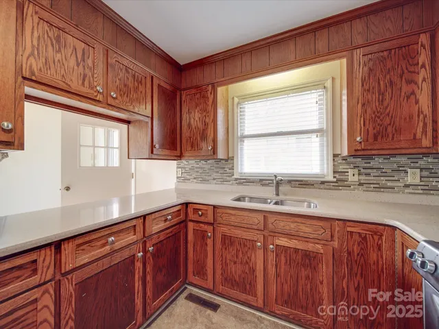 a kitchen with stainless steel appliances granite countertop a stove a refrigerator and a sink with wooden cabinets