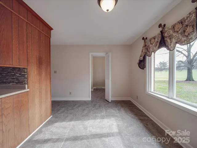 a view of kitchen with granite countertop cabinets and refrigerator