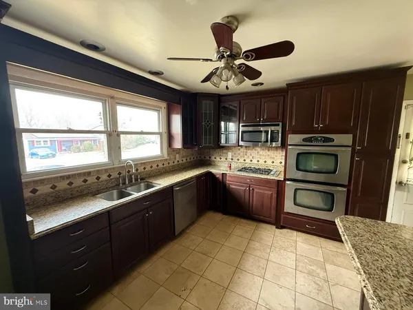 a kitchen with stainless steel appliances granite countertop a sink cabinets and window