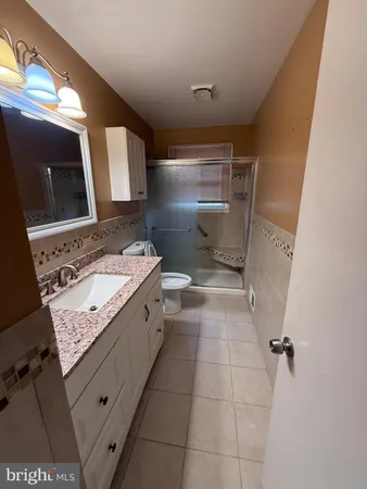 a bathroom with a granite countertop sink a toilet and mirror