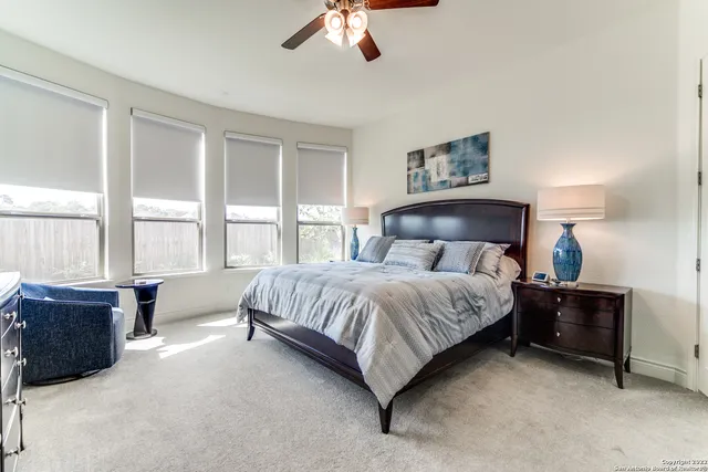 a spacious bedroom with a bed and a couch next to a window