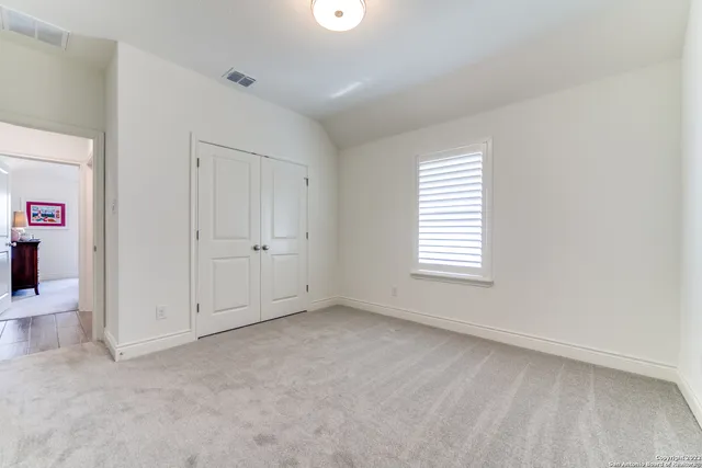 an empty room with windows and closet