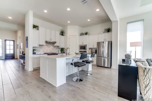 a kitchen with white cabinets and stainless steel appliances