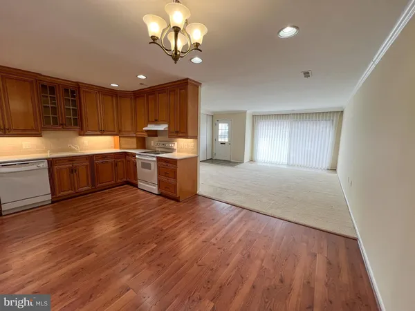 a large kitchen with stainless steel appliances granite countertop a stove and a large countertops with wooden floor