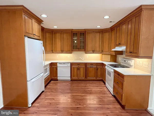 a kitchen with stainless steel appliances granite countertop a refrigerator and a stove top oven