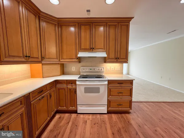 a kitchen with kitchen island granite countertop wooden cabinets and a stove