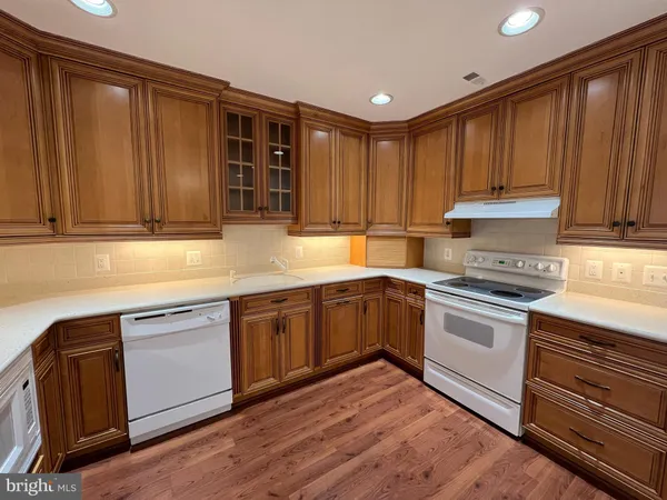 a kitchen with granite countertop wooden cabinets a sink and dishwasher
