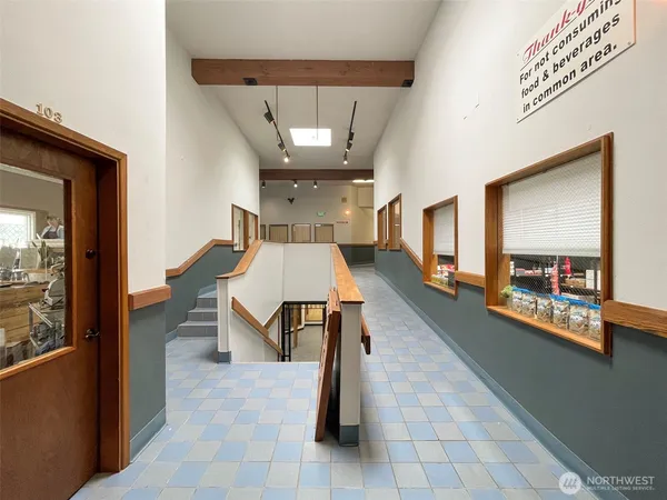 a view of a hallway with wooden floor and furniture