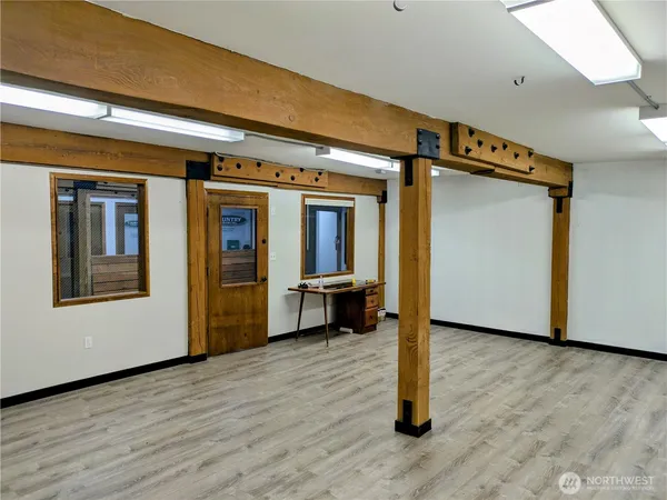 a view of a hallway with wooden floor and livingroom