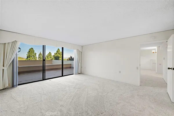 a view of an empty room with a kitchen