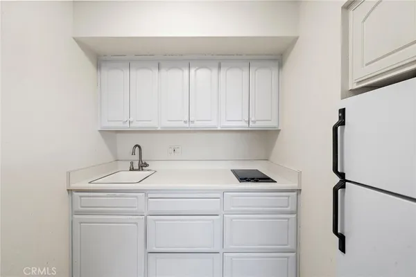a view of cabinets a sink and dishwasher in a white cabinet