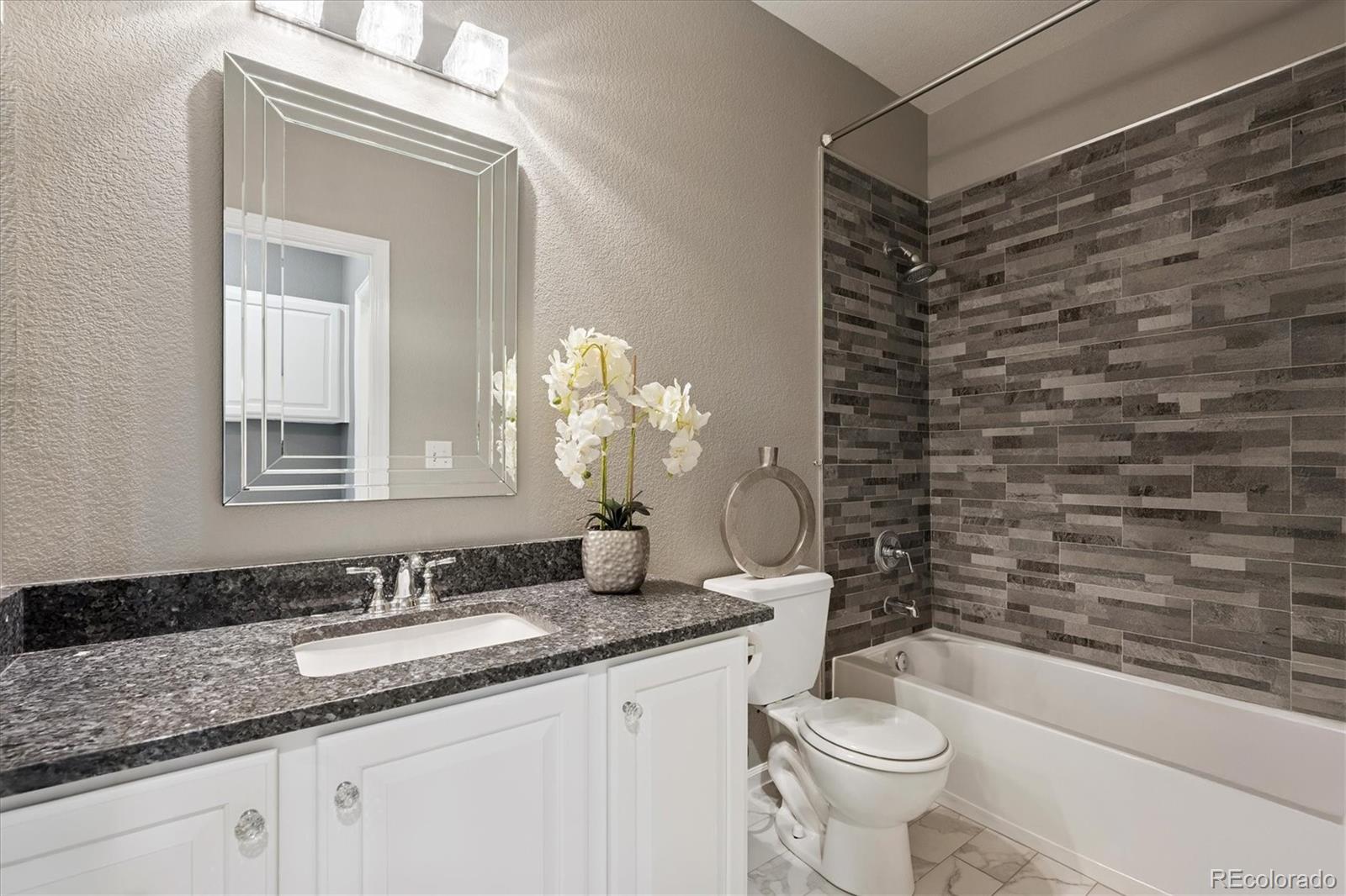 3350 Cascina Circle, Unit D Highlands Ranch, CO 80126 - Photo 17 of 40 a bathroom with a granite countertop sink toilet and shower