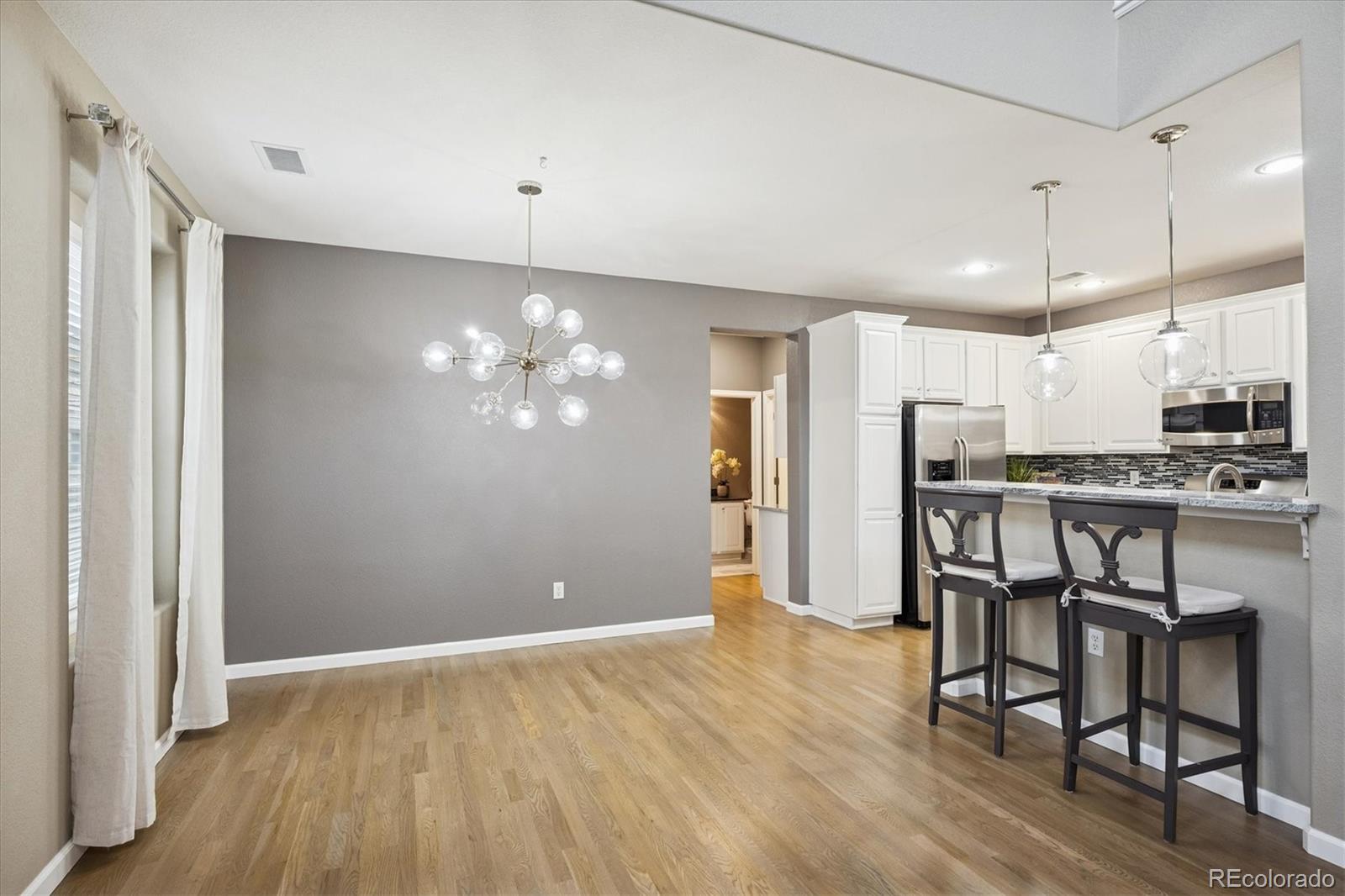 3350 Cascina Circle, Unit D Highlands Ranch, CO 80126 - Photo 10 of 40 a view of kitchen with refrigerator microwave and wooden floor