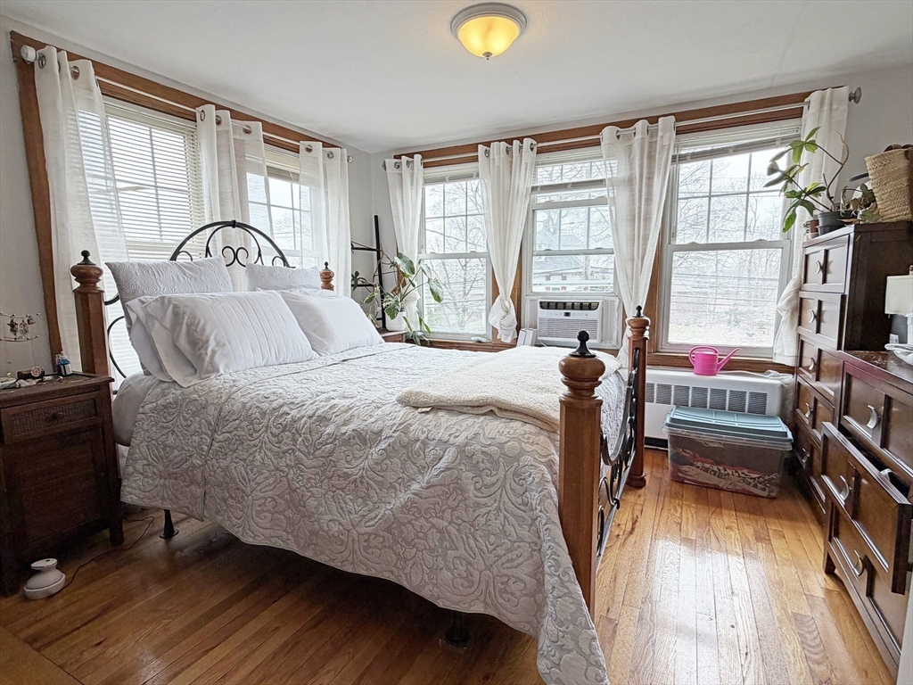 75-77 Dale Street, Unit 77 Waltham, MA 02451 - Photo 13 of 17 a bedroom with a bed and a large window with wooden floor