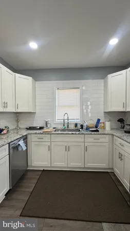a kitchen with granite countertop white cabinets and white appliances