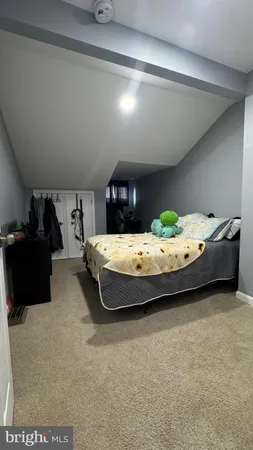a bedroom with a bed and a computer on the desk