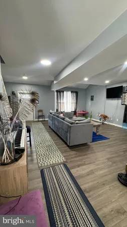 a living room with furniture a table and kitchen view