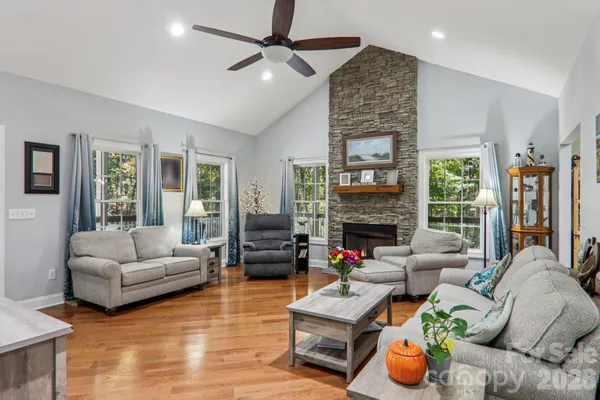 a living room with furniture fireplace and a large window