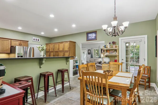 a view of a dining room with furniture a chandelier and wooden floor