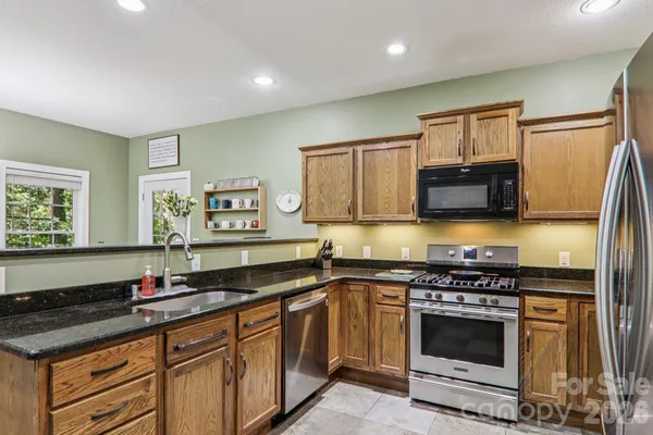 a kitchen with stainless steel appliances a stove sink microwave and cabinets