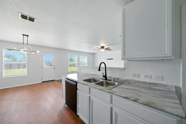 a kitchen with granite countertop a sink stainless steel appliances and cabinets