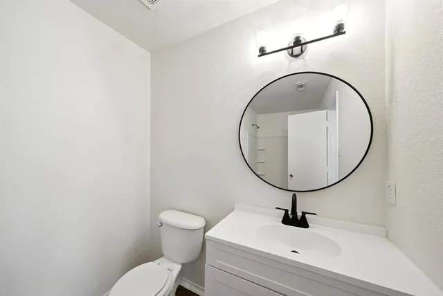 a bathroom with a toilet sink and mirror