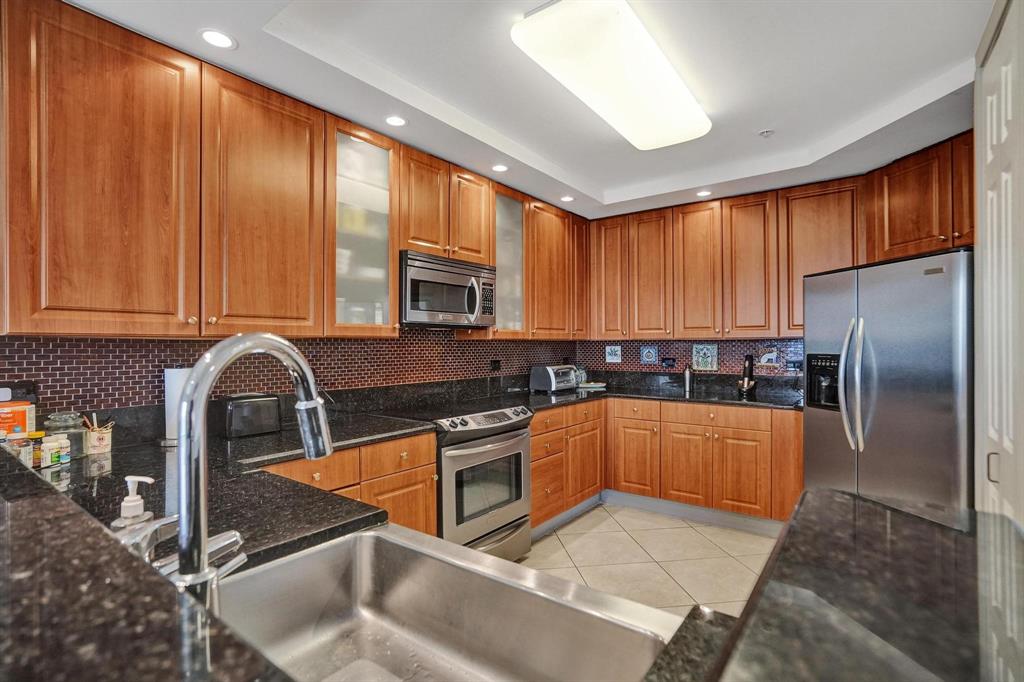 2633 Northeast 14th Avenue, Unit 400 Wilton Manors, FL 33334 - Photo 3 of 74 a kitchen with stainless steel appliances granite countertop a refrigerator a stove top oven and sink