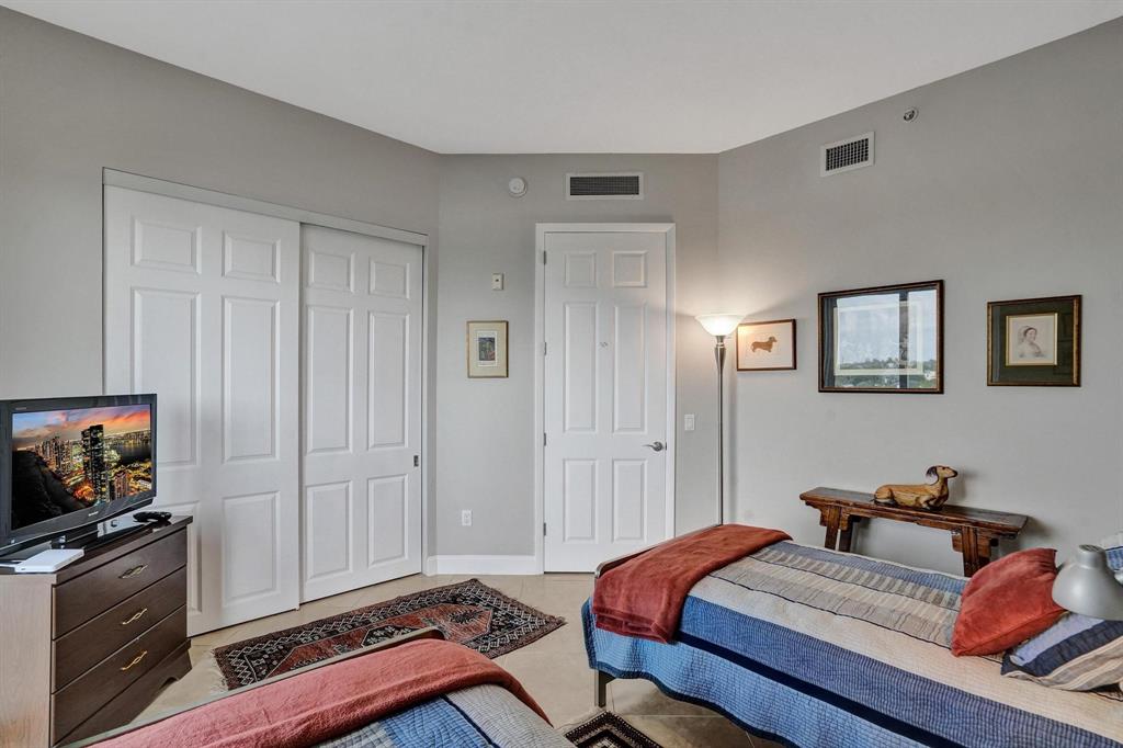 2633 Northeast 14th Avenue, Unit 400 Wilton Manors, FL 33334 - Photo 38 of 74 a bedroom with a bed and a flat screen tv