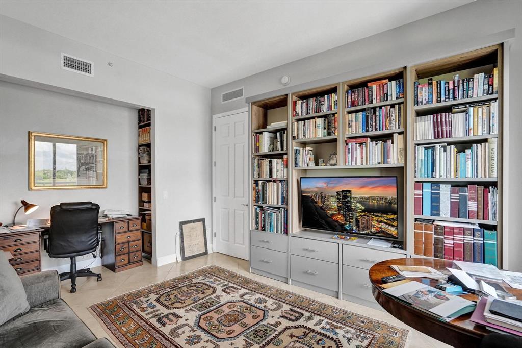 2633 Northeast 14th Avenue, Unit 400 Wilton Manors, FL 33334 - Photo 46 of 74 a living room with fireplace furniture and a book shelf
