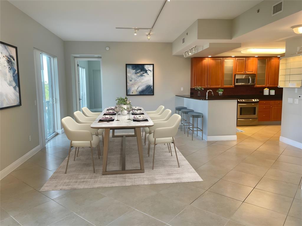 2633 Northeast 14th Avenue, Unit 400 Wilton Manors, FL 33334 - Photo 6 of 74 a dining room with furniture and a kitchen view