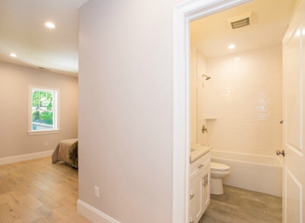 12 Suban Place, Unit 2 Newton, MA 02461 - Photo 8 of 13 a bathroom with a granite countertop toilet a sink and a mirror