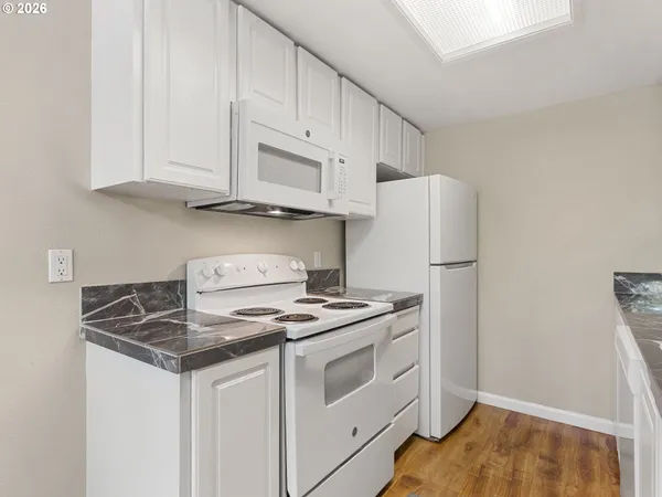 a kitchen with white cabinets and white appliances