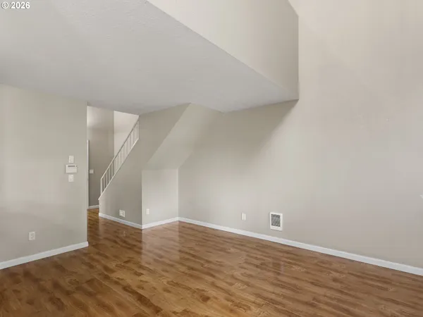 a view of an empty room with wooden floor