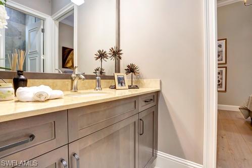 595 Regatta Road Naples, FL 34103 - Photo 33 of 40 Bathroom vanity with an integrated sink, polished chrome faucet, and light-toned countertop