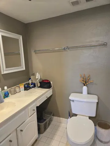 a bathroom with a sink mirror vanity and toilet