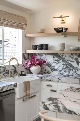 a kitchen with kitchen island granite countertop a sink and a stove
