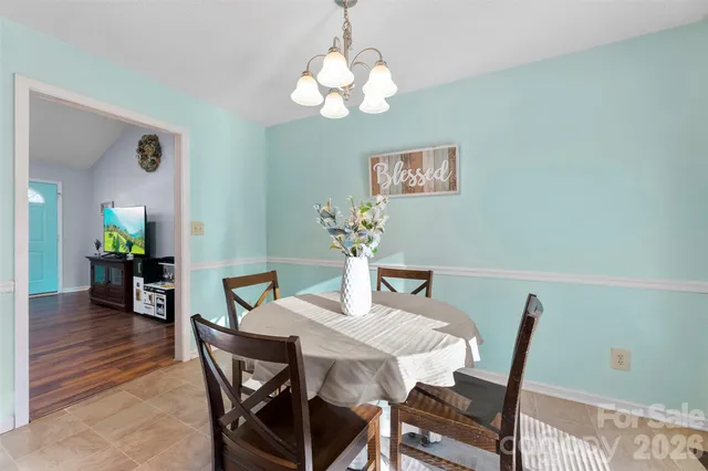 a dining room with furniture a chandelier and window