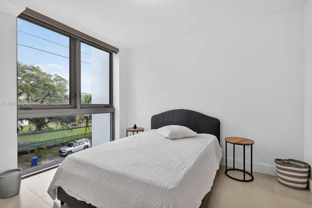 a bedroom with a bed and a large window
