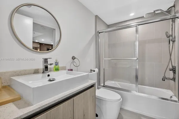 a bathroom with a sink a toilet and a mirror