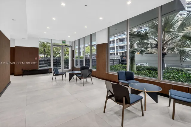 a dining room with furniture and large windows