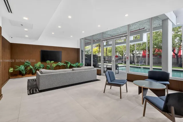 a living room with patio furniture and a floor to ceiling window