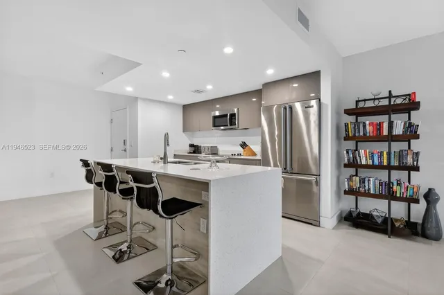 a kitchen with refrigerator and chairs