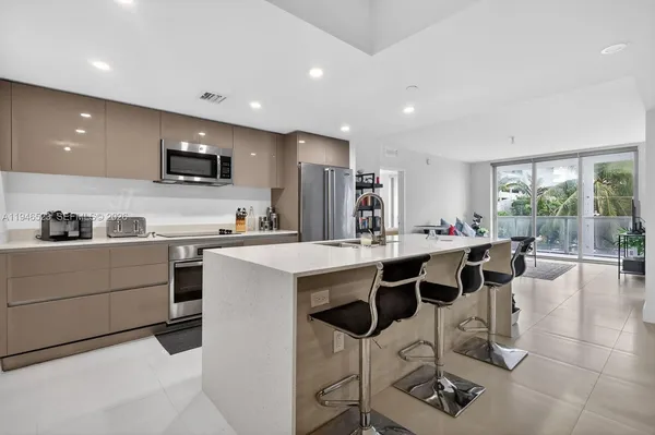 a kitchen with a dining table chairs and white cabinets