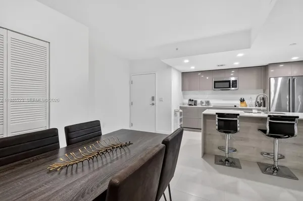 a kitchen with a table chairs microwave and cabinets