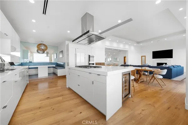a kitchen with stainless steel appliances a table chairs refrigerator and sink